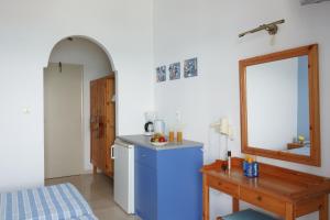 a small kitchen with a blue refrigerator and a table at Flisvos Rooms in Plakias