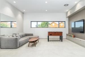 un salon avec un canapé et une table dans l'établissement Apartament RIVIERA Let's Sea z Basenem by BALTIC CLUB, à Gąski