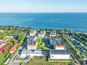une vue aérienne d'un campus scolaire à côté de l'océan dans l'établissement Apartament RIVIERA Let's Sea z Basenem by BALTIC CLUB, à Gąski
