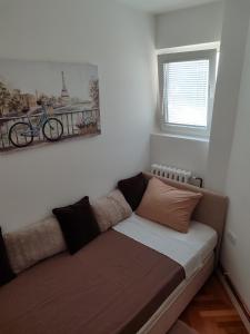 a couch in a room with a bike on the wall at New Belgrade Cozy Base in Belgrade