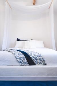 a white bed with a blue and white blanket on it at Oia Moon in Blaimont
