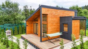 a tiny house on a deck with a bench at Nordic Dream Chalet in Buşteni +7 photos