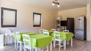 a room with green tables and white chairs and a refrigerator at Nordic Dream Chalet in Buşteni