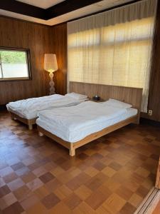 two twin beds in a bedroom with a window at mokumoku 山 ishioka in Mooka