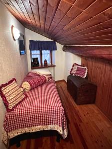 Un dormitorio con una cama y un techo de madera. en L'Atelier du Temps - Le Nid, en Aosta