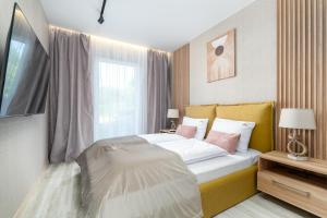 une chambre avec un grand lit et une fenêtre dans l'établissement Apartament RIVIERA Let's Sea z Basenem by BALTIC CLUB, à Gąski 21 autres photos