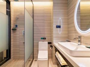 a bathroom with a sink and a toilet and a mirror at Xana Hotelle· Dalian Software Park University of Technology in Dalian +180 photos