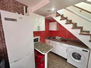 una cocina con lavadora y secadora y una escalera en Dunaflor Gemelo 2, en San Bartolomé