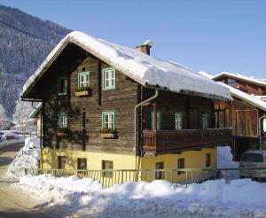 a wooden house with snow on the roof at Almliesl GAST-387 in Bad Gastein