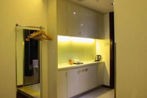 a kitchen with white cabinets and a sink at Guangzhou Hailian Hotel - Haizhu District Binjiang East Road Metro Station in Guangzhou