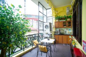 a balcony with a table and chairs and a window at CozyPosy Premier Apartment in Hanoi