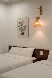 a bedroom with two beds and a pendant light at Benny Homestay Huế in Hue +55 photos