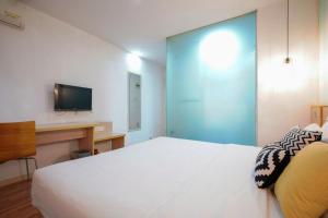 7 Days Inn Wuhan Hanzheng Street Shengli Road Metro Station في ووهان: غرفة نوم بسرير ابيض وتلفزيون على جدار +195 صورة