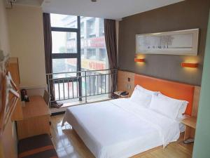 a bedroom with a white bed and a large window at 7 Days Premium Chongqing Fuling Binjiang Avenue Branch in Fuling +161 photos
