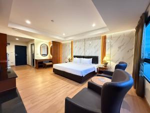 a hotel room with a bed and a living room at Nova Park Hotel Pattaya in Pattaya Central