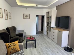 ビャウィストクにあるCentrum Apartment Lipowa 12の壁に薄型テレビが取り付けられたリビングルーム
