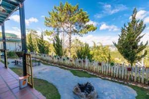 a backyard with a fire pit and a fence at Windy Hill Homestay Đà Lạt in Da Lat