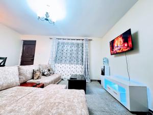 een woonkamer met een bank en een tv bij Executive homes in Kitengela 