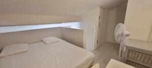 フレジュスにあるHouse for 4 with green yardの白いベッドと窓のある寝室 +9枚の写真