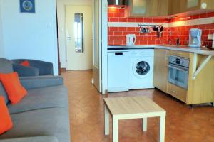 ein Wohnzimmer mit Sofa und eine Küche in der Unterkunft Comfortable apartment with pool facing the sea in Six-Fours-les-Plages