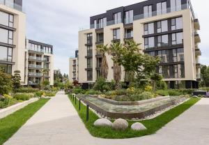 un jardin devant un immeuble dans l'établissement Chic One-Bedroom Getaway in Azur Deluxe Complex by Flat Mаnаger, à Saints Constantine et Helena