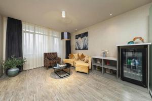 a living room with a couch and a tv at Jinjiang Metropolo Hotel Shenyang Country Garden Datong Lake Subway Station Branch in Shenyang