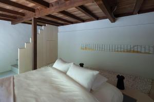 a bedroom with a white bed with white pillows at UTAHI  A 100-years-old Kyoto machiya in Kyoto