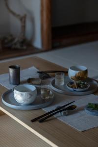 a table with two plates of food and chopsticks at UTAHI  A 100-years-old Kyoto machiya in Kyoto