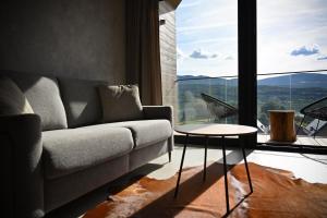 Una sala de estar con un sofá y una mesa y una ventana grande. en RentPlanet - Apartament Karkonoski, en Sosnówka