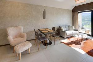 Una sala de estar con una mesa y sillas y un sofá. en RentPlanet - Apartament Karkonoski, en Sosnówka