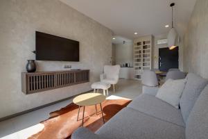 Una sala de estar con un sofá y un televisor en una pared. en RentPlanet - Apartament Karkonoski, en Sosnówka 11 fotos más