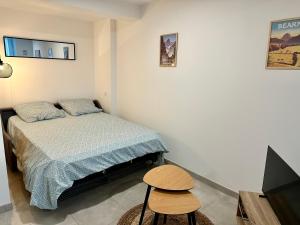 a small bedroom with a bed and a stool at Studio Cosy en vallée d'Ossau in Izest