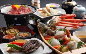 una mesa cubierta con diferentes tipos de comida en platos en 城崎温泉お宿白山花まんだら, en Toyooka 7 fotos más