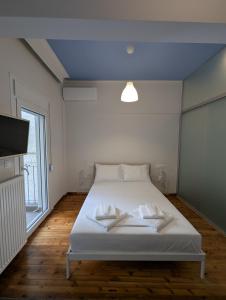 a bedroom with a bed with two white towels on it at Hippodrome Cute - Blue in Thessaloniki
