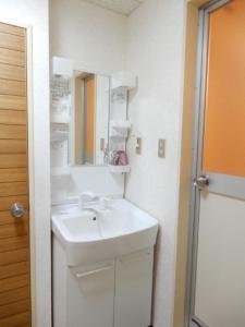a bathroom with a white sink and a mirror at Ueda Building - Vacation STAY 8565 in Asahikawa