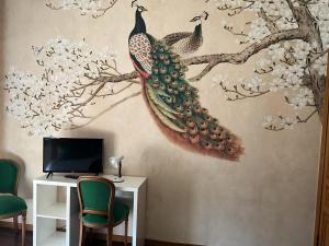 a wall mural of two birds sitting on a tree branch at Beb la terrazza in Iesi