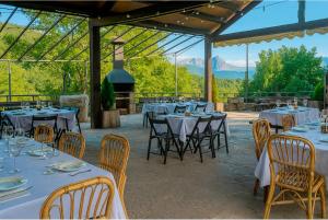 a restaurant with tables and chairs with mountains in the background at Albergue La Escuela de Liri in Lirí