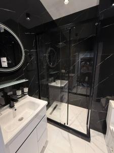 a bathroom with a glass shower and a sink at моя квартира in Yakkasaray