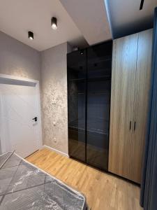 a bedroom with a bed and a large glass closet at моя квартира in Yakkasaray