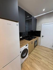 a kitchen with a washing machine and a washer at моя квартира in Yakkasaray