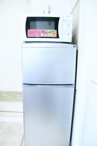 a microwave sitting on top of a refrigerator at Ueda Building - Vacation STAY 8554 in Asahikawa