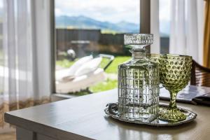 szklana butelka i kieliszek do wina na stole w obiekcie Villa Toscana Boutique w Murzasichlu +59 zdjęć