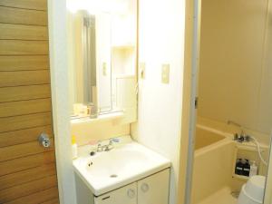 a bathroom with a sink and a tub and a mirror at Ueda Building - Vacation STAY 8563 in Asahikawa