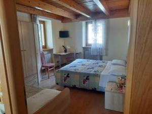 a bedroom with a bed and a table and a desk at AlpinaBnB in Castello Tesino