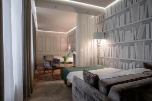 a hotel room with a bed and a couch and a desk at Jump INN Hotel Belgrade in Belgrade