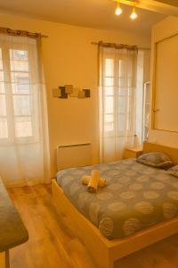 Un dormitorio con una cama con un osito de peluche encima. en Appartement 4 voyageurs avec terrasse et WIFI - Proche Cité Médiévale, en Carcassonne