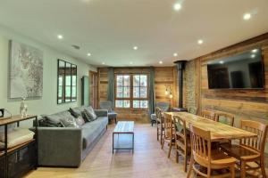a living room with a couch and a table at ARC 1950 - Appartement 10 personnes Duplex Cheminée - ski aux pieds - Sauna, Hammam, Jacuzzi, Piscine in Arc 1950