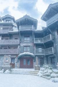 a large building with snow on the ground in front of it at ARC 1950 - Appartement 10 personnes Duplex Cheminée - ski aux pieds - Sauna, Hammam, Jacuzzi, Piscine in Arc 1950