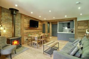 a living room with a couch and a fireplace at ARC 1950 - Appartement 10 personnes Duplex Cheminée - ski aux pieds - Sauna, Hammam, Jacuzzi, Piscine in Arc 1950