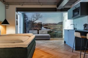 a bedroom with a large window with a river view at Hotel Skjern in Skjern
